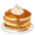 Three pancakes in a stack topped with syrup and whipped cream displayed as an emoji