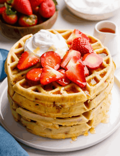 Sweet Strawberry Waffles topped with fresh strawberries and whipped cream
